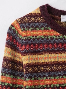 Detail of round neck Fair Isle knit cardigan with colorful geometric jacquard pattern