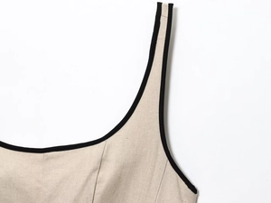 Detailed macro view of beige linen texture with contrasting black piping and stitching
