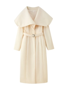 Detailed view of women's off-white coat with large lapels, belted waist, and pleated hem