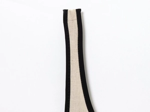 Close-up of beige linen midi dress showing black trim contrast and neat stitching detail