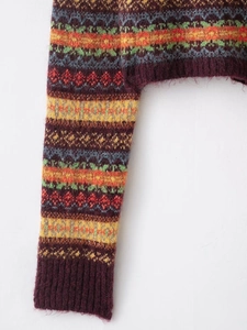 Detail of vintage Fair Isle knit cardigan sleeve with colorful geometric jacquard patterns