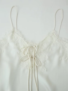 Vue détaillée d'un caraco en satin blanc avec dentelle cils et détail de nœud délicat