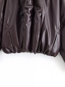 Detailed macro view of elastic hem and quilted texture on dark brown PU leather jacket