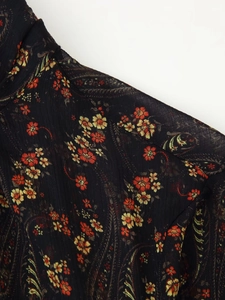 Detail of floral and paisley print on black chiffon fabric with ruffled texture