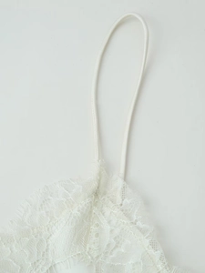 Détail de dentelle cils délicate et fines bretelles sur une robe en satin blanc