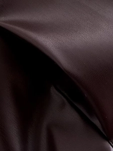 Macro shot of dark brown faux leather texture featuring natural lychee grain details
