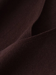 Dettaglio ravvicinato della maglia bordeaux scuro con trama fine e cuciture piatte