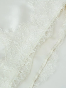 Détail du bord en satin blanc orné de dentelle fine avec finition cils brodée