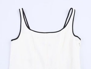 Detail of white linen top with black contrast piping and hidden side zipper closure
