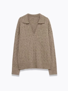 Macro shot of cable knit texture and polo collar on a beige knitted sweater