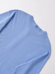 Close-up of light blue knit top showing fine ribbed neckline and soft fabric texture