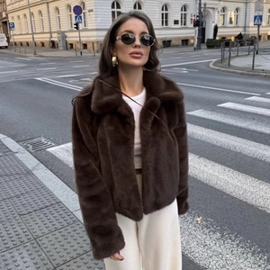 Short faux fur coat in dark brown with lapel collar shown in an urban street setting