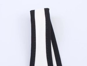 Macro detail of the black and white contrast fabric strap with precise stitching on dress