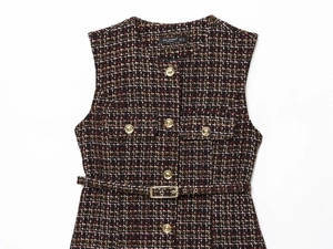 Close-up of textured tweed vest with metallic gold buttons and matching belt detail