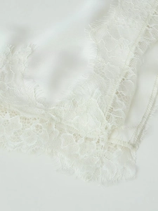 Détail macro du tissu satiné blanc avec une bordure délicate en dentelle de cils fins