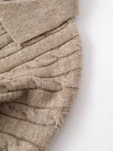 Macro shot of oatmeal cable knit fabric texture and ribbed collar on women sweater