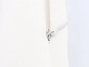 Detail of invisible zipper on white linen midi dress showing fabric texture and quality