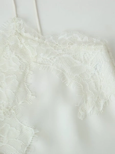 Détail de la dentelle délicate et du tissu satiné sur la robe blanche à bretelles