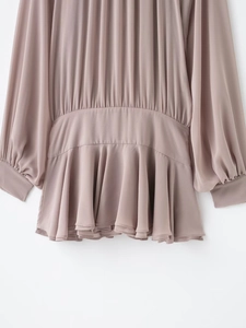 Detalle del vestido de gasa rosa plisado con cintura alta y dobladillo con volantes