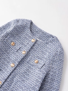 Detail of tweed texture and gold buttons on blue women's elegant round neck jacket