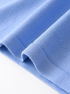 Macro shot of sky blue flat knit fabric texture with soft ribbed edge detail