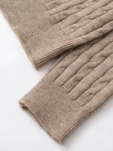 Detailed macro view of beige cable knit sweater texture and chunky knit pattern