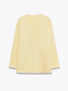 Detail of light yellow Henley neck long sleeve top with textured vertical ribbing