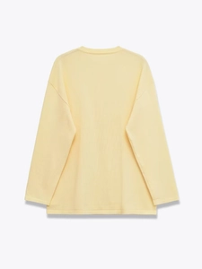 Detail view of the back of a light yellow crew neck sweatshirt with neat hem stitching