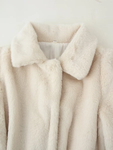 Detailed close-up of thick beige faux fur lapel and smooth lining on the luxury coat