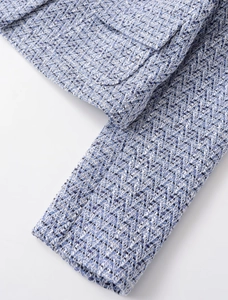 Detail of blue and white tweed fabric texture with flap pocket on the woven jacket