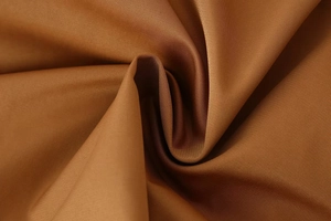 Detailed view of bronze twill fabric with metallic sheen and elegant spiral draping