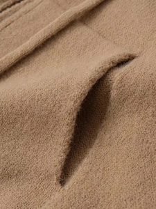 Macro shot of brown knit sweater pocket showing detailed fabric texture and stitching