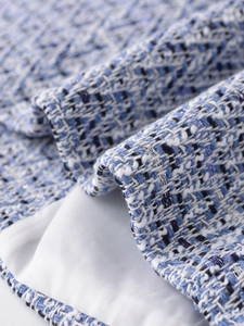 Macro shot of blue and white tweed fabric texture with metallic silver threads