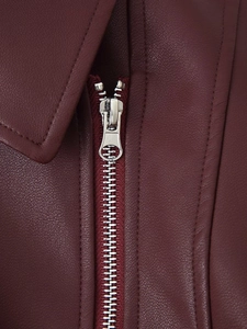 Détail d'une veste en cuir bordeaux avec fermeture éclair argentée et tirette à logo