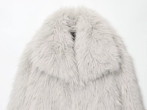Gros plan sur le large revers d'un manteau en fausse fourrure grise avec texture peluche