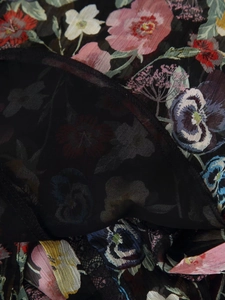 Gros plan sur la robe en mousseline fleurie montrant les coutures et le tissu transparent