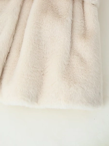 Close-up of soft beige faux fur coat texture showing thick plush material and smooth fibers