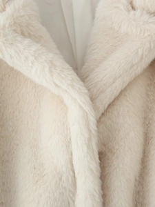 Close-up of plush faux fur coat collar in cream white with premium smooth inner lining