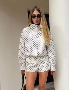 Detail einer weißen Seersucker-Jacke mit schwarzen Punkten und modischem Stehkragen