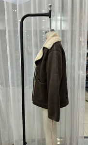 Detail view of deep brown faux suede jacket with white faux lamb wool collar and pockets