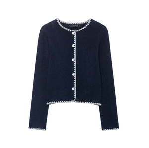 Close-up of navy knit cardigan featuring white scalloped edges and pearl-like buttons