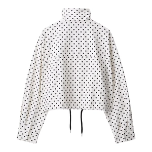Close-up of women's polka dot jacket featuring a high collar and drawstring hem detail