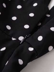Macro view of the invisible zipper design on black fabric with white polka dots