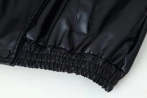 Détail de la veste en cuir avec ourlet élastique froncé et bouton-pression métallique