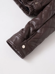Detail of dark brown quilted PU jacket showing diamond stitching and metal snap cuff