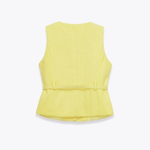 Detail of yellow tweed vest back with slim belt and elegant peplum hemline