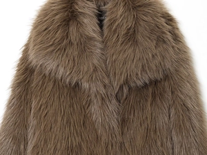 Gros plan du manteau en fausse fourrure montrant la texture épaisse et le large revers