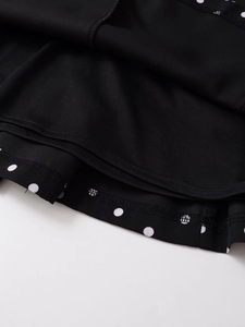 Detail of internal overlock stitching on black polka dot V-neck halter dress fabric