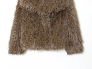 Détail du manteau en fausse fourrure marron montrant la texture épaisse et le col
