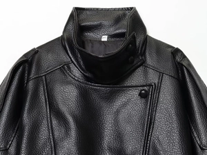 Detailopname van zwart kunstleren bikerjack met kiezeltextuur en opstaande kraagdetails